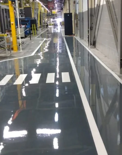 Piso de fábrica com revestimento epóxi cinza de alta resistência — acabamento brilhante, pronto para tráfego de empilhadeiras