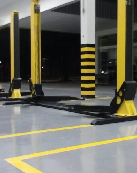 Piso de oficina mecânica pintado com tinta epóxi — superfície resistente a óleo e graxa, com demarcação de área