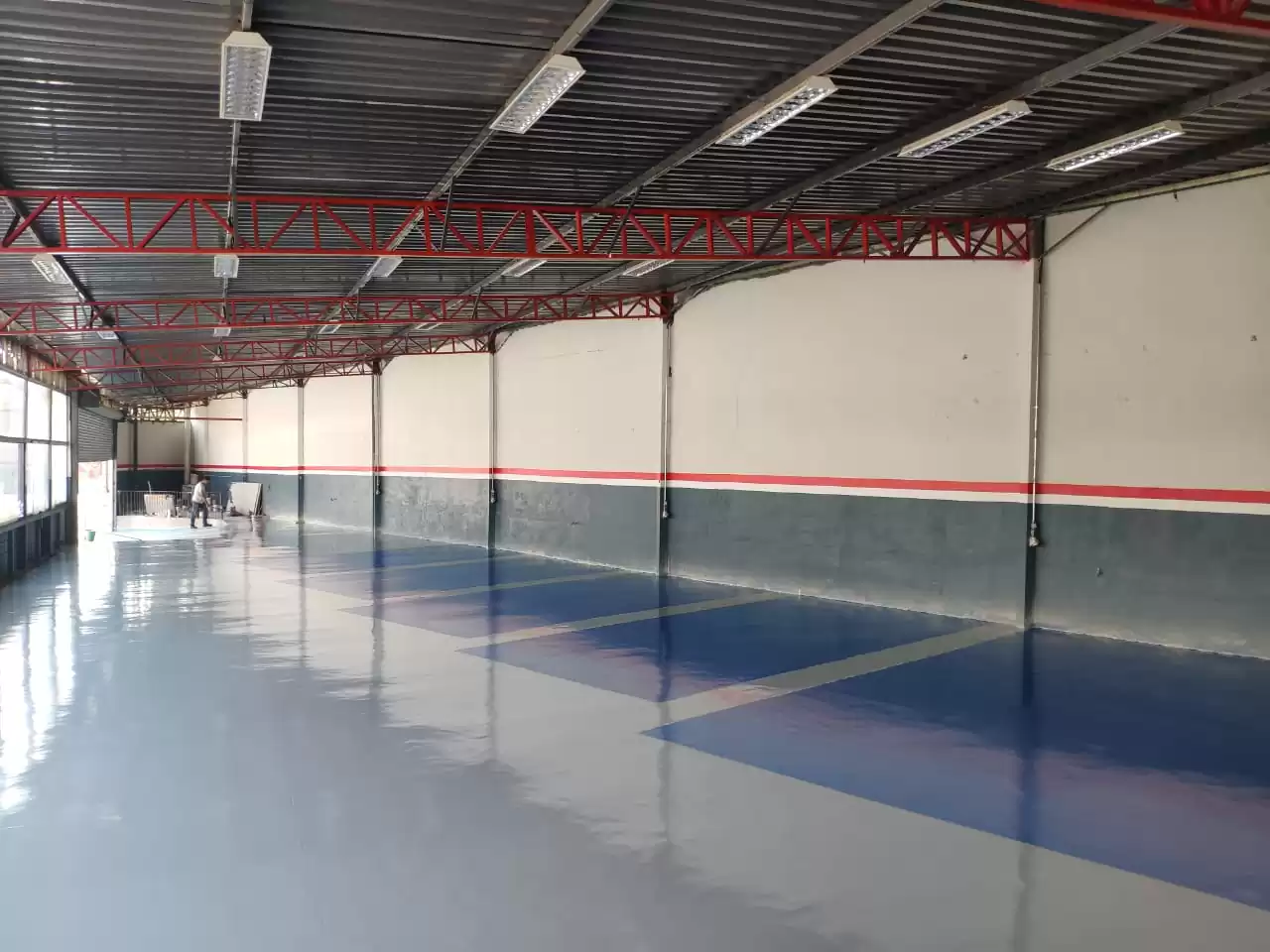 Oficina mecânica com piso pintado com tinta epóxi — demonstrando resistência e durabilidade do produto